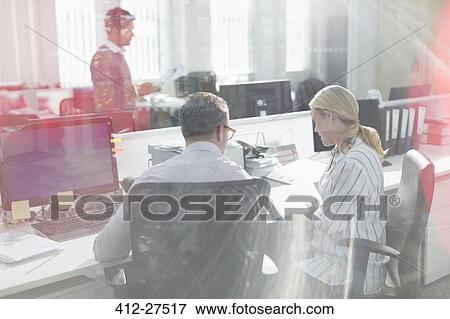Business people reviewing paperwork at desk in office View Large Photo Image Stock Photo - Business people reviewing paperwork at desk in office. Fotosearch