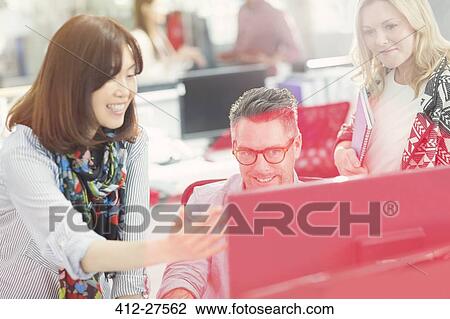 Stock Image - Business people working at computer in office. Fotosearch