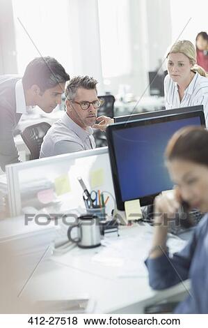 Stock Photo - Business people working at computer in office. Fotosearch
