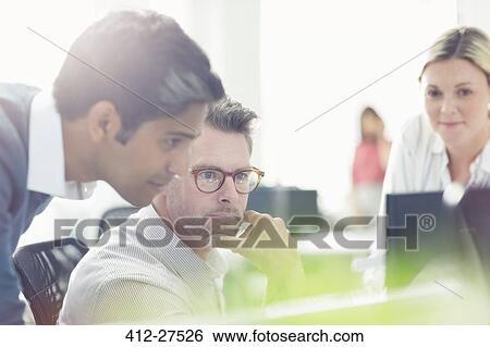 Business people working at computer in sunny office View Large Photo Image Stock Photograph - Business people working at computer in sunny office. Fotosearch