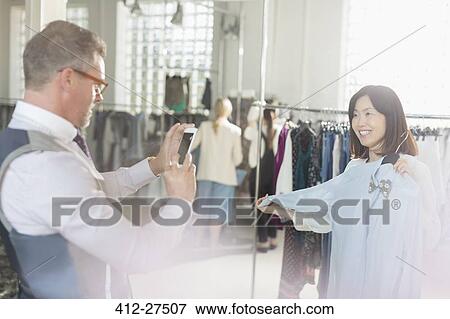 Fashion designer photographing colleague with shirt View Large Photo Image Stock Photo - Fashion designer photographing colleague with shirt. Fotosearch