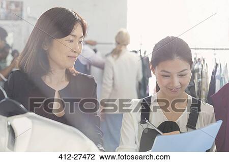 Fashion designer watching assistant taking notes View Large Photo Image Stock Image - Fashion designer watching assistant taking notes. Fotosearch
