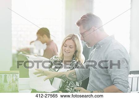 Fashion designers discussing fabric swatch in sunny office View Large Photo Image Stock Photography - Fashion designers discussing fabric swatch in sunny office. Fotosearch