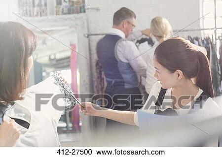 Fashion designers examining clothing in office View Large Photo Image Stock Image - Fashion designers examining clothing in office. Fotosearch