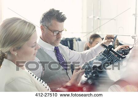 Fashion designers examining clothing View Large Photo Image Stock Image - Fashion designers examining clothing. Fotosearch