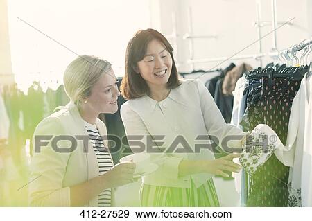 Fashion designers examining cuff detail on blouse View Large Photo Image Stock Photo - Fashion designers examining cuff detail on blouse. Fotosearch