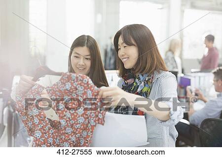 Fashion designers examining dress View Large Photo Image Stock Photography - Fashion designers examining dress. Fotosearch