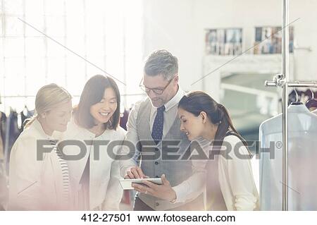 Fashion designers sharing digital tablet in office View Large Photo Image Stock Image - Fashion designers sharing digital tablet in office. Fotosearch