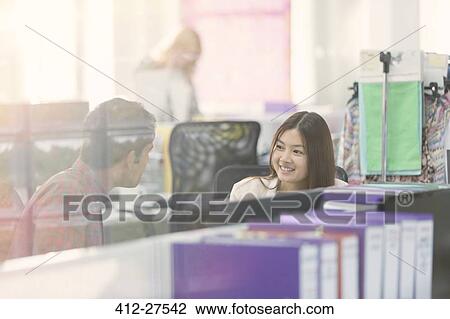 Fashion designers talking at desk in office View Large Photo Image Stock Image - Fashion designers talking at desk in office. Fotosearch