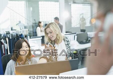 Fashion designers working at computer in office View Large Photo Image Stock Photo - Fashion designers working at computer in office. Fotosearch