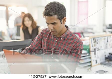 Focused businessman working in office View Large Photo Image Stock Photo - Focused businessman working in office. Fotosearch