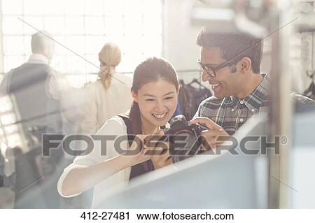Photographer and fashion designer looking down at camera View Large Photo Image Stock Image - Photographer and fashion designer looking down at camera. Fotosearch