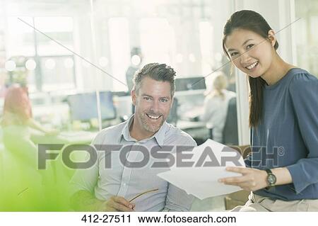 Portrait smiling business people reviewing paperwork in office View Large Photo Image Stock Image - Portrait smiling business people reviewing paperwork in office. Fotosearch