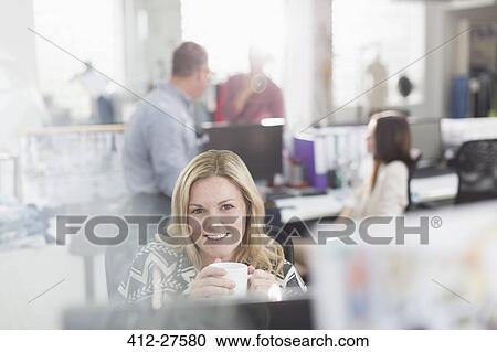Portrait smiling fashion designer drinking coffee at computer in office View Large Photo Image Stock Image - Portrait smiling fashion designer drinking coffee at computer in office. Fotosearch