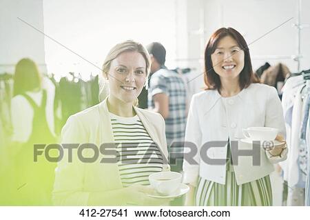 Portrait smiling fashion designers drinking tea View Large Photo Image Stock Image - Portrait smiling fashion designers drinking tea. Fotosearch