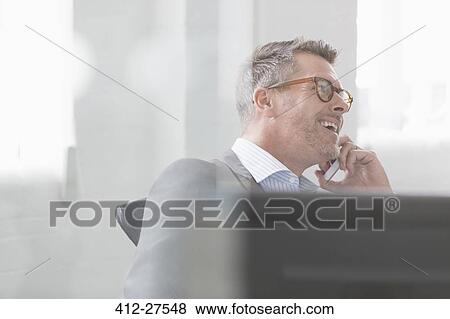 Smiling businessman talking on cell phone View Large Photo Image Stock Photo - Smiling businessman talking on cell phone. Fotosearch