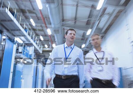 Stock Photograph - Businessmen walking in factory. Fotosearch