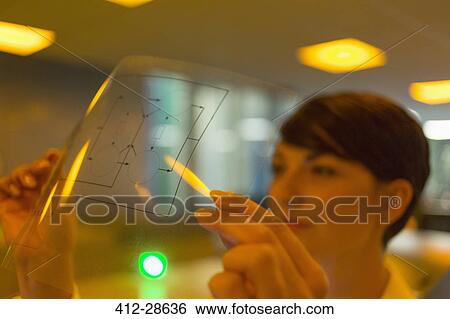 Stock Photograph - Close up woman examining diagram transparency. Fotosearch