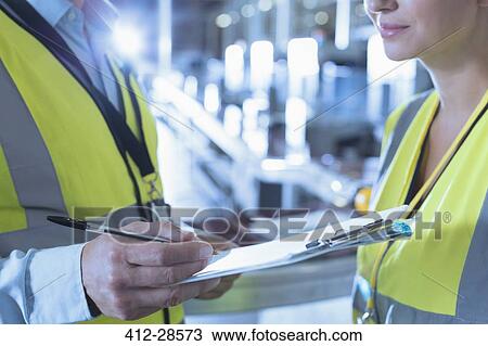 Close up worker and supervisor with clipboard in factory View Large Photo Image Stock Image - Close up worker and supervisor with clipboard in factory. Fotosearch