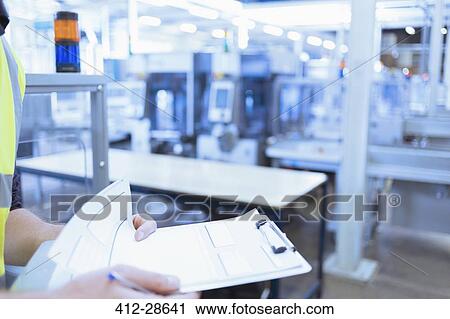 Close up worker with clipboard in factory View Large Photo Image Stock Image - Close up worker with clipboard in factory. Fotosearch