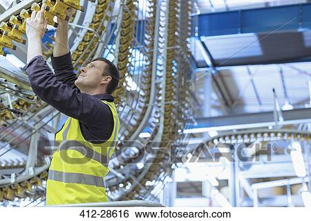 Engineer examining printing press conveyor belt View Large Photo Image Stock Photograph - Engineer examining printing press conveyor belt. Fotosearch