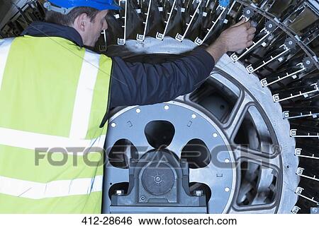 Stock Photograph - Engineer examining printing press machinery. Fotosearch