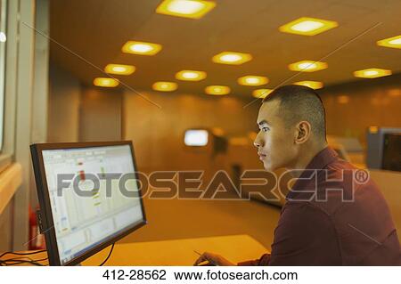 Engineer working at computer in factory control room View Large Photo Image Stock Image - Engineer working at computer in factory control room. Fotosearch