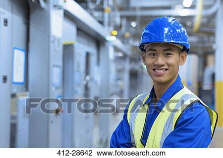 Portrait smiling worker in hard-hat in factory View Large Photo Image Stock Image - Portrait smiling worker in hard-hat in factory. Fotosearch