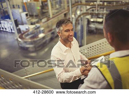 Supervisor and worker handshaking in factory View Large Photo Image Stock Image - Supervisor and worker handshaking in factory. Fotosearch