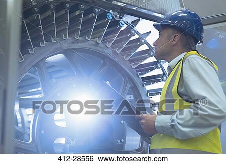 Supervisor with clipboard examining machinery in printing plant View Large Photo Image Stock Photograph - Supervisor with clipboard examining machinery in printing plant. Fotosearch