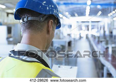 Stock Photograph - Worker with clipboard in factory. Fotosearch