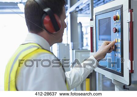 Worker with ear protectors at control panel in machinery View Large Photo Image Stock Photo - Worker with ear protectors at control panel in machinery . Fotosearch