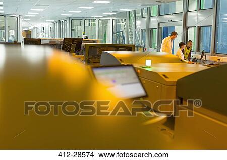 Workers at computer behind printers in printing plant View Large Photo Image Picture - Workers at computer behind printers in printing plant. Fotosearch
