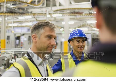 Workers talking in factory View Large Photo Image Picture - Workers talking in factory. Fotosearch