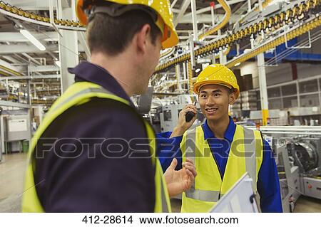 Workers talking in factory View Large Photo Image Picture - Workers talking in factory. Fotosearch