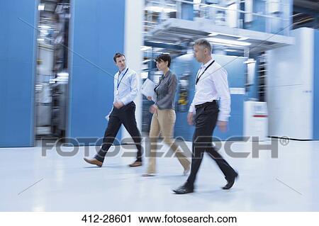 Workers walking in factory View Large Photo Image Stock Image - Workers walking in factory. Fotosearch
