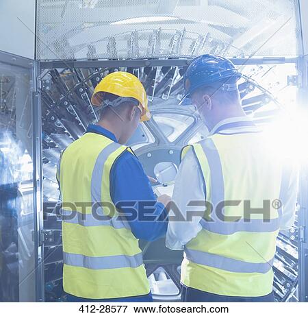 Workers with clipboard checking machinery in printing plant View Large Photo Image Stock Photo - Workers with clipboard checking machinery in printing plant. Fotosearch