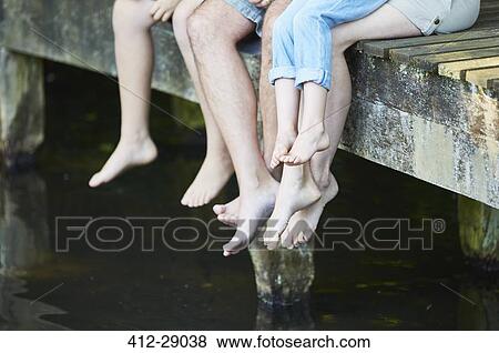 Family dangling bare feet over dock View Large Photo Image Stock Photo - Family dangling bare feet over dock. Fotosearch