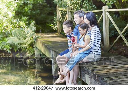 Family sitting at the edge of dock View Large Photo Image Stock Photo - Family sitting at the edge of dock. Fotosearch