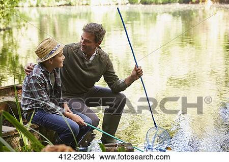 Picture - Father and son fishing with nets in pond. Fotosearch