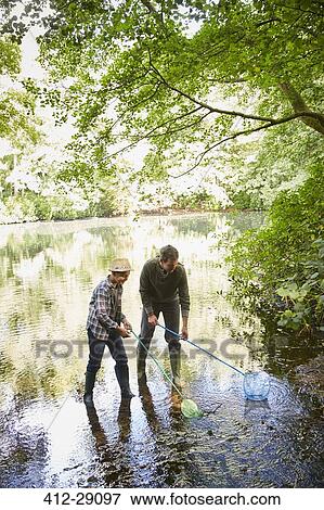 Father and son fishing with nets in pond View Large Photo Image Stock Photo - Father and son fishing with nets in pond. Fotosearch