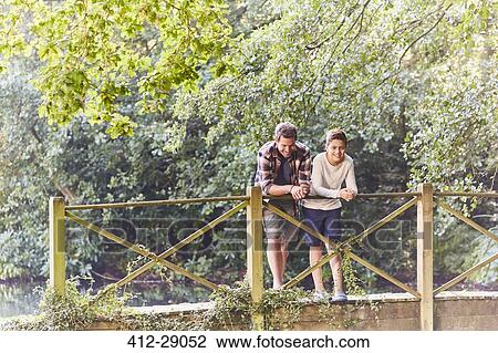 Father and son on footbridge in park with trees View Large Photo Image Stock Image - Father and son on footbridge in park with trees. Fotosearch