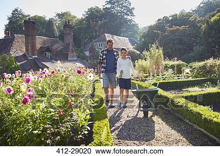 Stock Image - Father and son walking in sunny garden. Fotosearch
