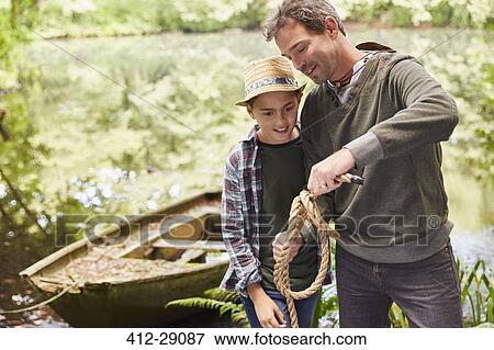 Stock Photo - Father teaching son how to tie a rope knot. Fotosearch
