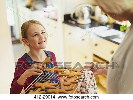 Picture - Grandmother and granddaughter baking gingerbread cookies. Fotosearch
