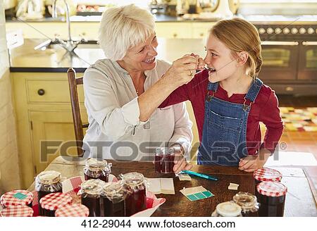 Grandmother and granddaughter canning jam in kitchen View Large Photo Image Picture - Grandmother and granddaughter canning jam in kitchen. Fotosearch