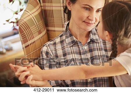 Stock Image - Mother and daughter holding hands face to face. Fotosearch