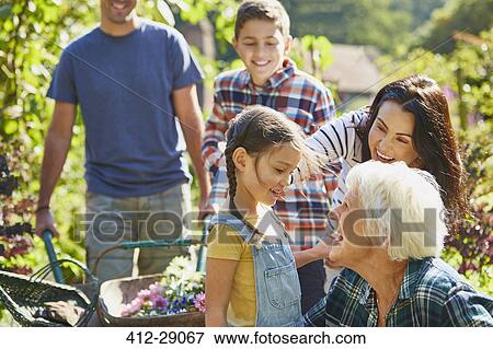 Stock Photo - Multi-generation family bonding in sunny garden. Fotosearch