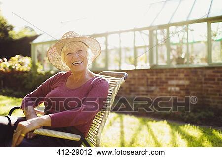Portrait enthusiastic senior woman sitting outside sunny greenhouse View Large Photo Image Stock Image - Portrait enthusiastic senior woman sitting outside sunny greenhouse. Fotosearch