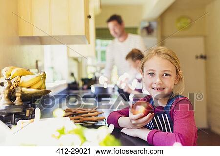 Portrait smiling girl eating apple in kitchen View Large Photo Image Stock Image - Portrait smiling girl eating apple in kitchen. Fotosearch